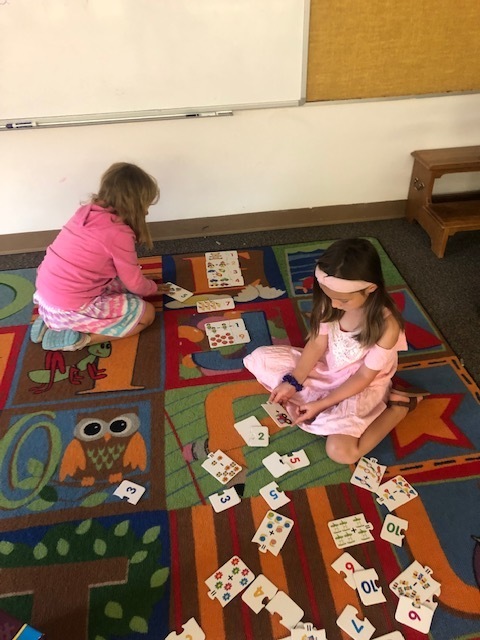 Summer school students working with math flash cards on a carpet
