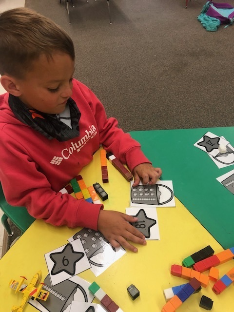Summer school student working on adding numbers with cubes