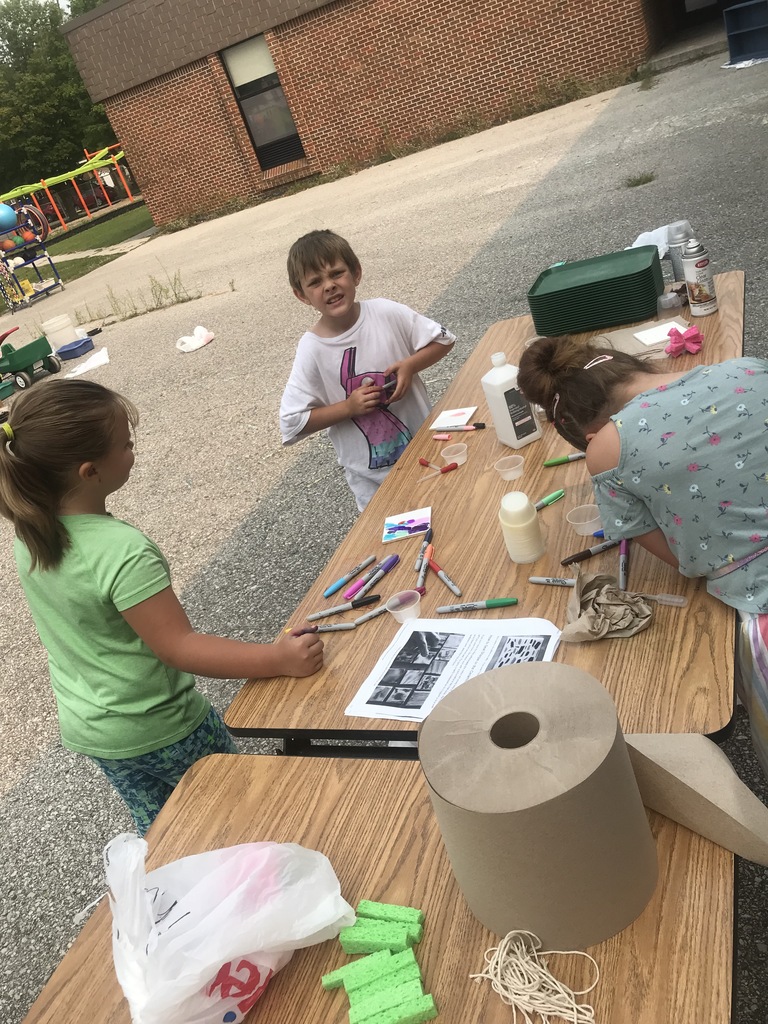 Students outside drawing with makers