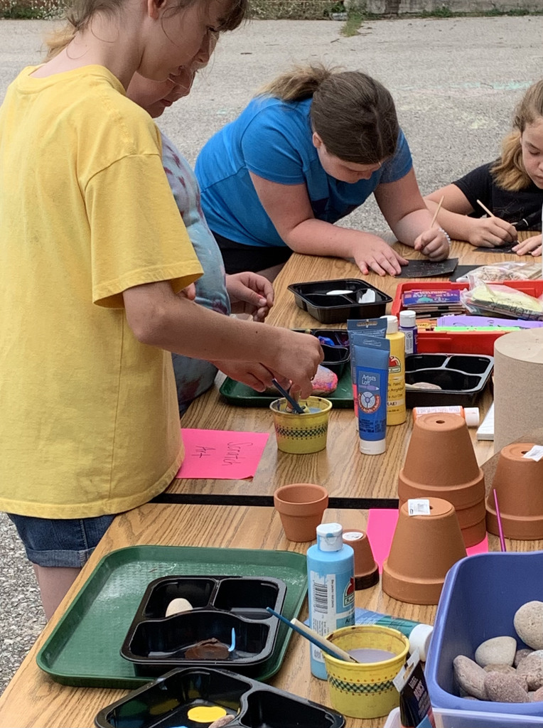 Students outside painting and doing scratch art