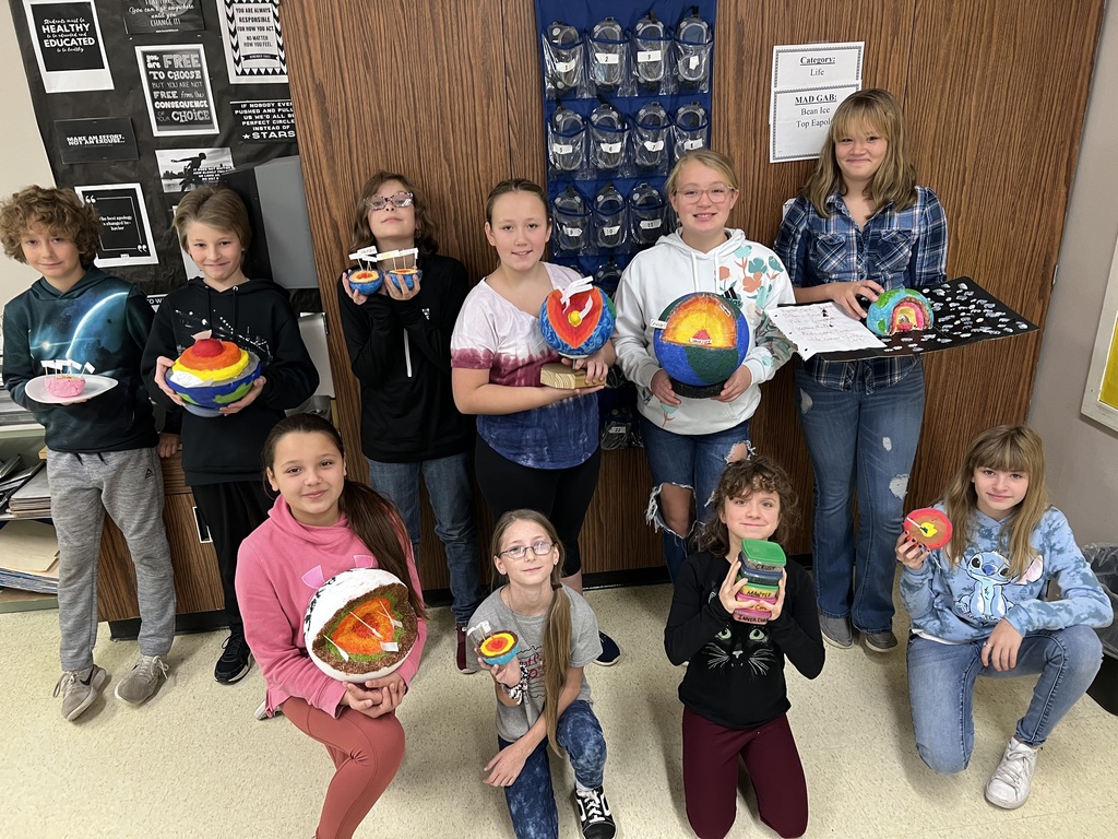 6th grade students holding their models of the Earth.